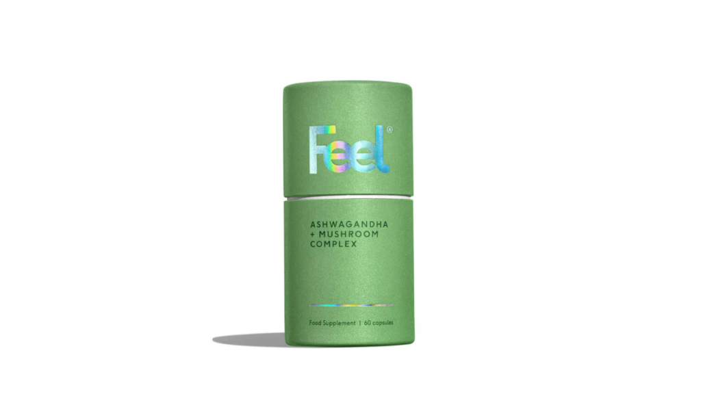 A green cylindrical container of Feel Ashwagandha + Mushroom Complex, featuring a minimalist design with holographic lettering. The label highlights the product as a food supplement containing 60 capsules, promoting stress resilience and overall wellness through adaptogenic ingredients.